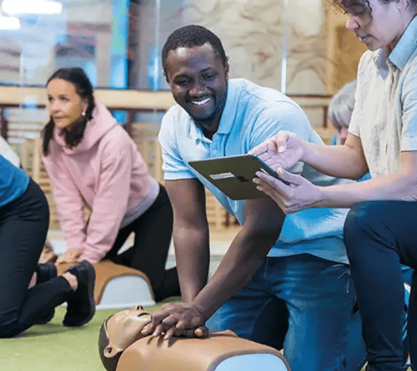 Group practicing CPR on manikins